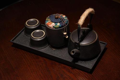 a tray with a tea pot and three candles at L'Hôtel in Kunming