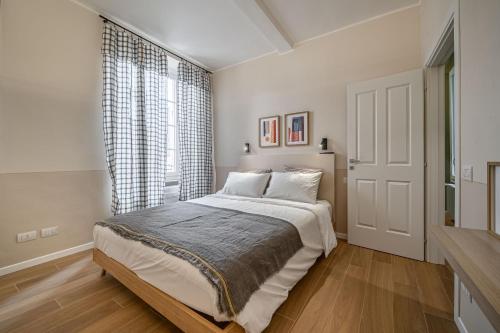 a white bedroom with a bed and a window at Borgo delle Botteghe Luxury Suites in Parma