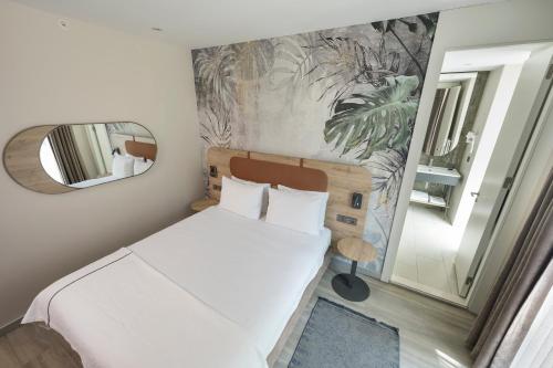 a small bedroom with a bed and a mirror at Upsuites Hotel in Istanbul