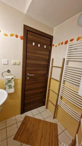 a bathroom with a wooden door and a sink at Kamzík Donovaly in Donovaly