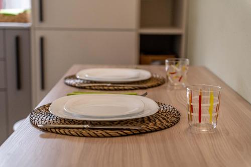 a table with three white plates and glasses on it at Borgo delle Botteghe Luxury Suites in Parma