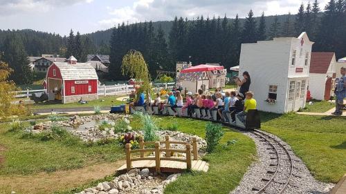 a group of children sitting on a miniature train at Kamzík Donovaly in Donovaly