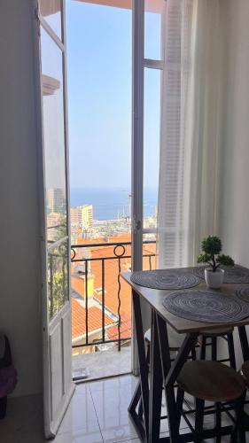 Cette chambre dispose d'une table et d'un balcon avec vue. dans l'établissement Seaview Apartment with 1 Bedroom - Next to Monaco, à Beausoleil