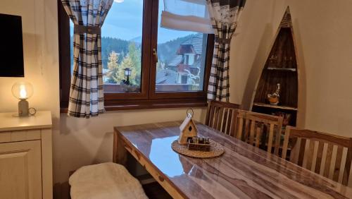 a dining room with a table and a large window at Kamzík Donovaly in Donovaly
