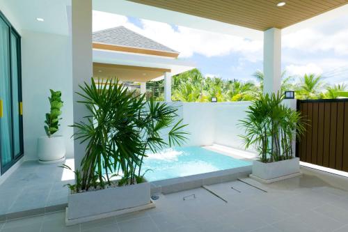 a swimming pool in a house with two potted plants at Relax Nai Yang beach pool Villas in Nai Yang Beach