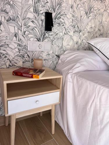 a bed with a nightstand next to a bed with a bed sqor at A Casiña Laranxa in Cangas de Morrazo