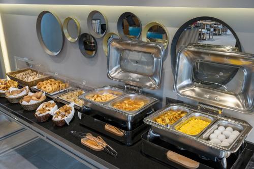 a buffet with eggs and other food in trays at Upsuites Hotel in Istanbul