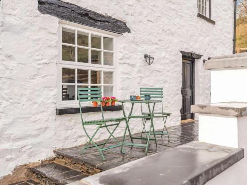 a table with flowers on it in front of a building at 3 bed in Corwen 86266 in Corwen