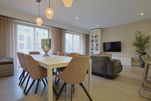 a living room with a table and chairs and a couch at STYLISH 3 BED Partial SEAVIEW in St. Julianʼs