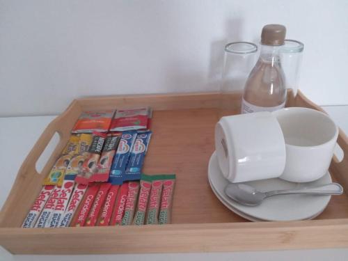 a wooden tray with a cup and a plate and a bottle of water at Lefa Guesthouse in Ledig