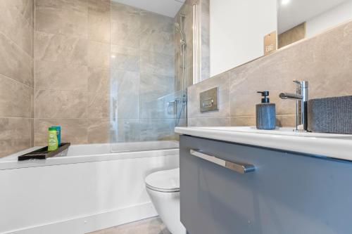 a bathroom with a sink and a toilet and a tub at York Penthouse with Hot Tub & View of Minister in York