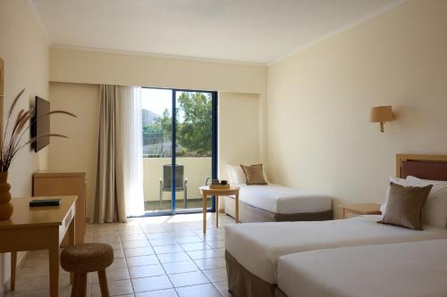 a hotel room with two beds and a window at Kiotari Bay in Kiotari