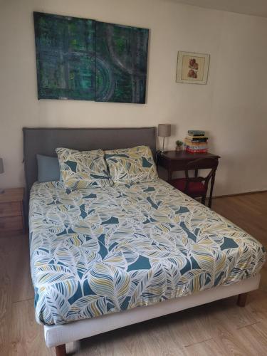 - un lit avec une couette bleue et blanche dans une chambre dans l'établissement Centre historique à 2 pas du musée RIGAUD, à Perpignan