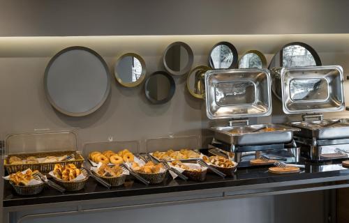a buffet with many different types of food and mirrors at Upsuites Hotel in Istanbul