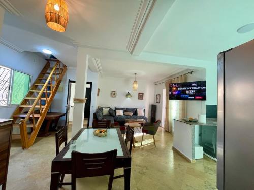 Una sala de estar con una mesa y sillas y un sofá. en Beautiful apartment in front of the sea, en Sidi Bouzid