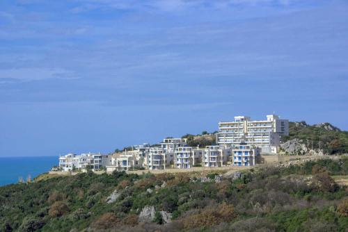 a building on top of a hill next to the ocean at VISTA Kalamper MONTENEGRO in Dobra Voda