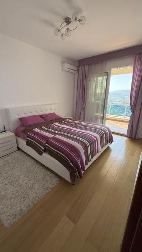 a bedroom with a bed and a large window at VISTA Kalamper MONTENEGRO in Dobra Voda
