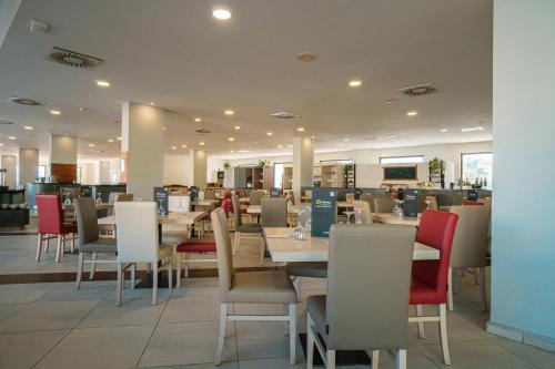 a dining room with tables and chairs in a restaurant at Ohtels Campo De Gibraltar in La Línea de la Concepción