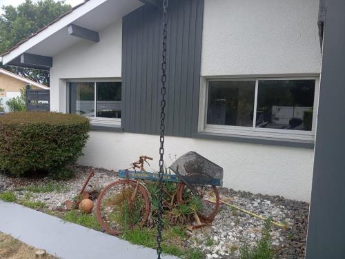 un vélo enchaîné sur le côté d'une maison dans l'établissement T2 Charmant et calme, à Andernos-les-Bains