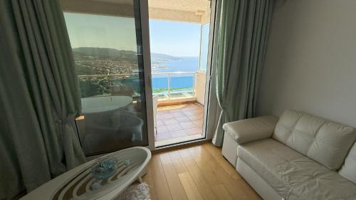 a living room with a couch and a large window at VISTA Kalamper MONTENEGRO in Dobra Voda
