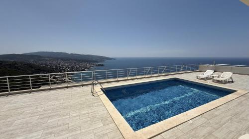 a swimming pool on top of a house with the ocean at VISTA Kalamper MONTENEGRO in Dobra Voda