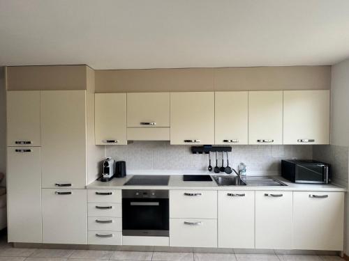 a kitchen with white cabinets and a sink at Mary s home in Morbio Inferiore