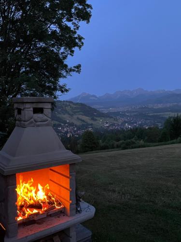 a brick oven with a fire in a field at Chata na Grapie in Biały Dunajec