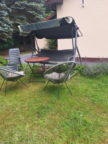 a picnic table and chairs in the grass at Apartamenty Dom nad Jeziorem in Głęboczek