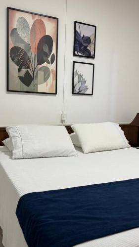 アルフェナスにあるHotel Douradoのベッドルーム1室(ベッド2台付)が備わります。壁に3枚の写真が飾られています。
