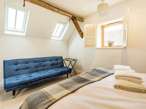 una camera da letto con un divano blu e un letto di 3 Bed in Eckington 86760 a Eckington