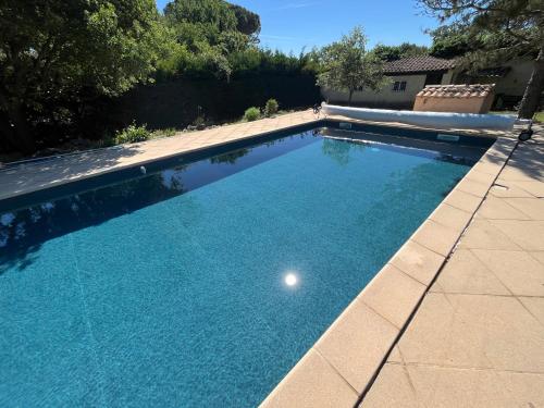 une piscine avec de l'eau bleue dans une cour dans l'établissement Villa Provençale piscine privée, à Saint-Maximin-la-Sainte-Baume