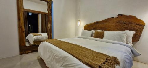 a bedroom with a large bed with a large mirror at Peaceful 2BR House with Rice Field View Near Beach & Local Spots in Mendaya