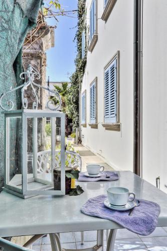 a table with two cups and saucers on a balcony at Zì Maria in Marina di Cecina