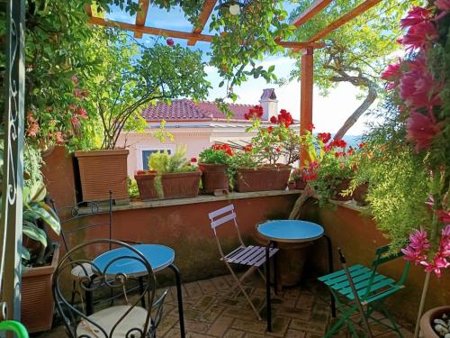 a patio with two tables and chairs and flowers at Casa San Biagio in Palestrina