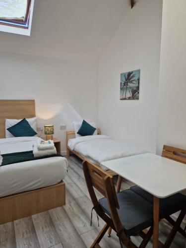 a room with two beds and a table and a desk at Crown House in Oxford
