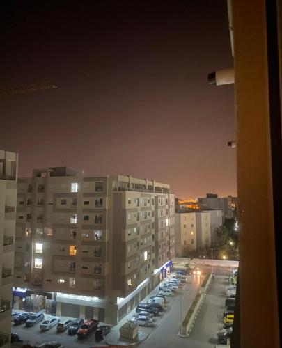 vistas a un aparcamiento nocturno con edificios en Apart s2 ain zaghouen la marsa, en La Marsa