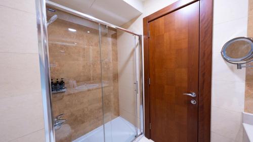 a shower with a glass door in a bathroom at Acacia Hotel by Blue Collection in Ras al Khaimah