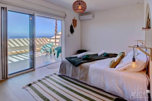 a bedroom with a bed and a view of the ocean at La KazArmor et sa vue panoramique sur l'océan in Les Avirons