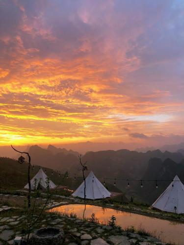 a group of three white tents at sunset at Sunrise Camping Ha Giang Lung Cu in Ha Giang