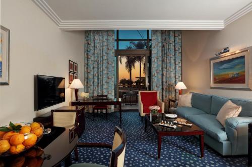 a living room with a blue couch and a table at Le Royal Hotel - Beirut in Beirut