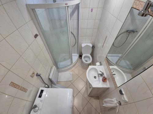 a bathroom with a sink and a toilet and a mirror at Dom wakacyjny u Beaty nad Jeziorem Rożnowskim in Bartkowa-Posadowa