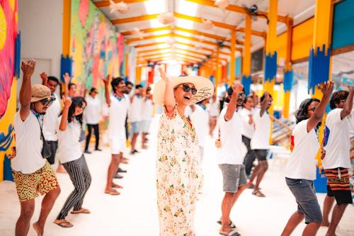 a woman standing in front of a crowd of people at Oaga Art Resort Maldives - Greatest All Inclusive Plan with Free Speedboat Round-trip in North Male Atoll