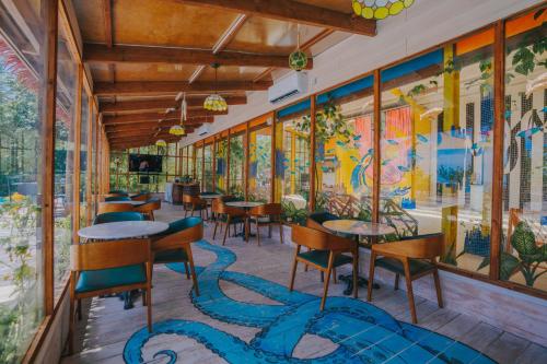 a restaurant with tables and chairs and a mural on the wall at Oaga Art Resort Maldives - Greatest All Inclusive Plan with Free Speedboat Round-trip in North Male Atoll