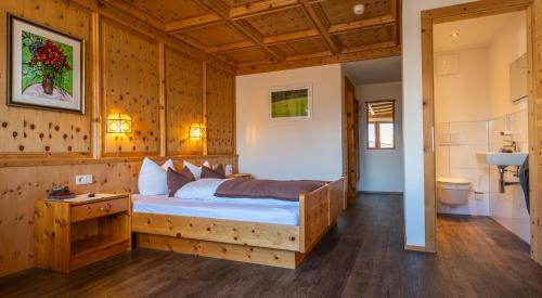 a bedroom with a bed and a bathroom with a sink at Aparthotel Fernblick in Fiss