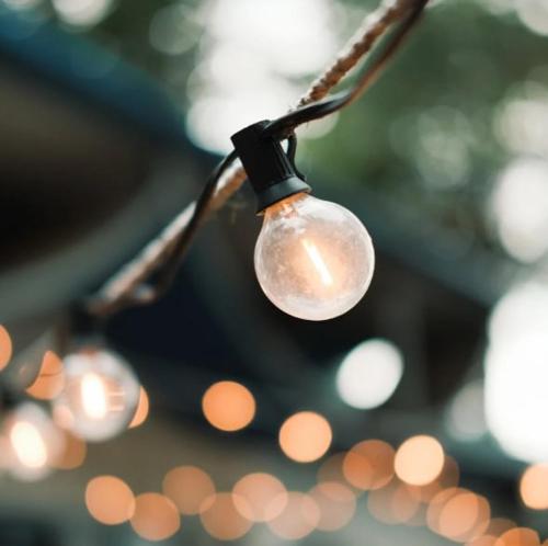a light bulb hanging from a string with lights at Cosy Lakeside Lodge - Water Views - Min 3 Night Stay in Dunning