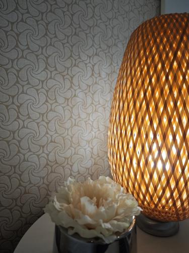 a lamp and a white flower in a black vase at Quinta do Botas in Cabeceiras de Basto