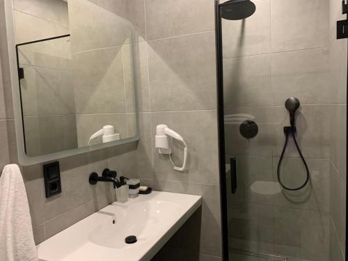 a bathroom with a shower and a sink and a mirror at Bilychi - садиба у Карпатах in Bilichi