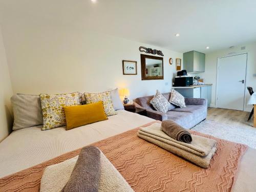 a living room with a large bed and a couch at Romantic Cabin Retreat on 50-Acre Suffolk Farm in Burgh