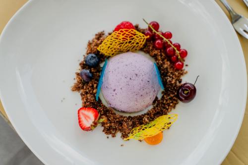 a white plate with a dessert with fruit on it at Wellnesshotel Rothfuß mit Spa und 2 Schwimmbädern in Bad Wildbad