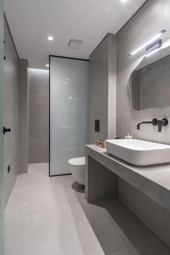 a bathroom with a white sink and a toilet at Milva Mare Luxury Apartments in Kos
